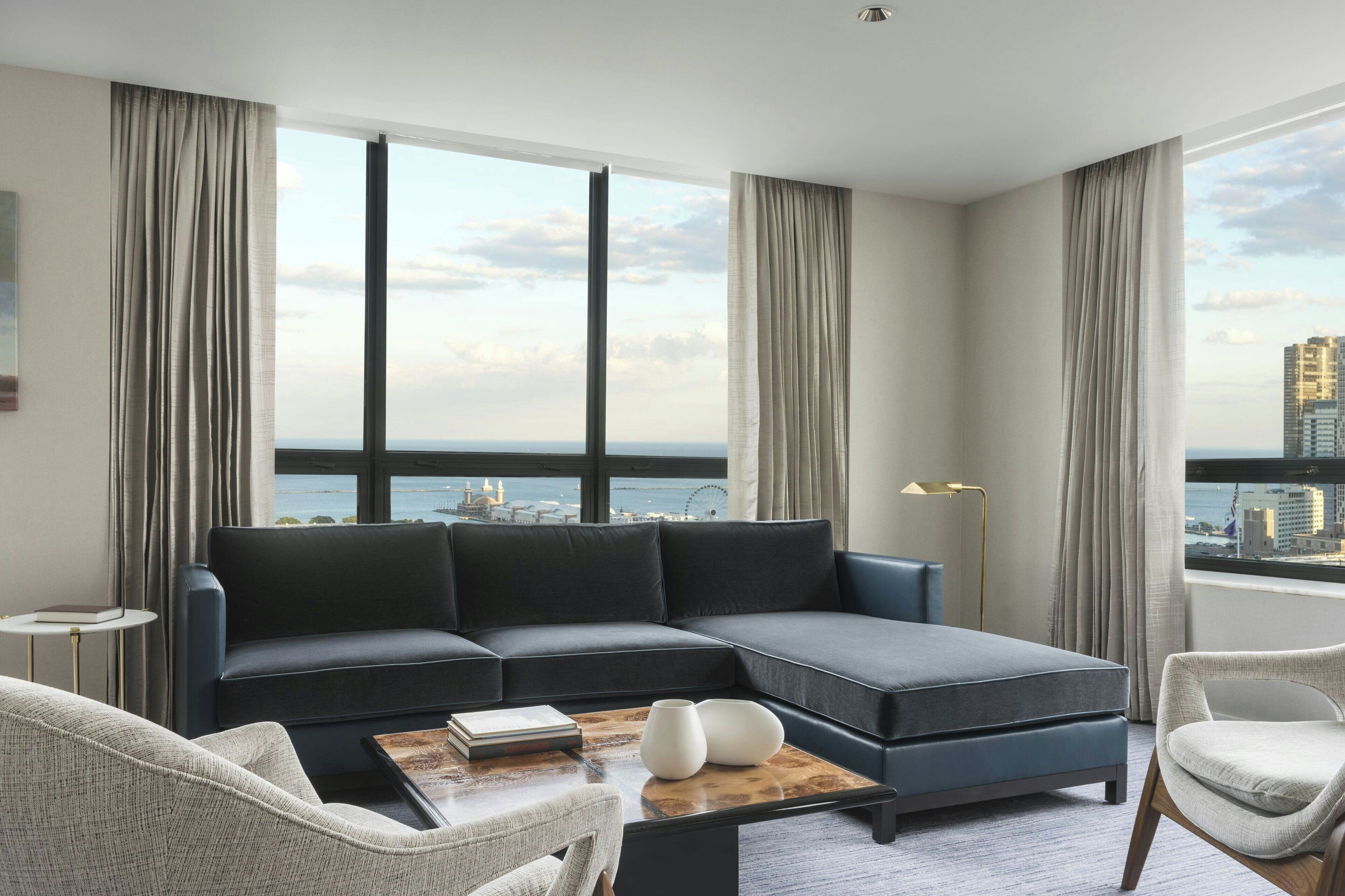 A modern living room with a sectional sofa, a coffee table, and a view of the cityscape.