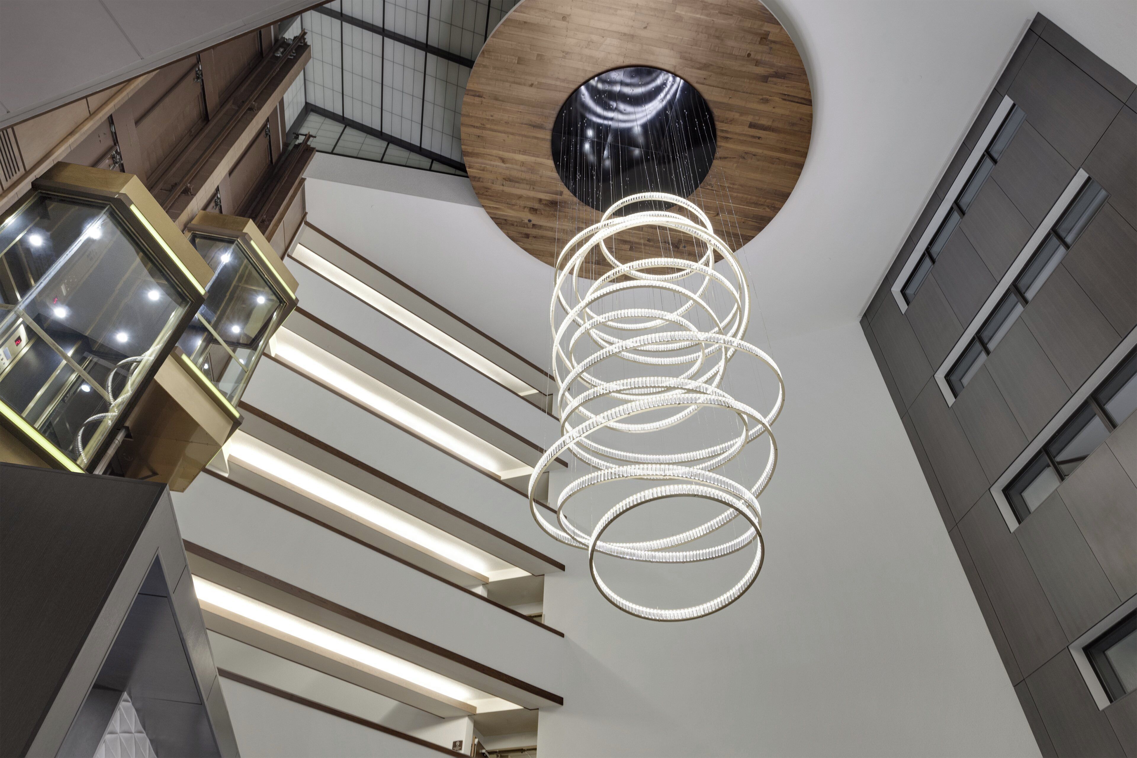 A modern interior with a spiral light fixture and a wooden accent wall.