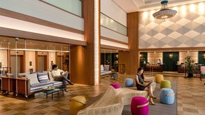 A spacious lobby with a checkered floor, a reception desk, and seating areas with colorful ottomans. - JEN Penang Georgetown by Shangri-La (George Town)