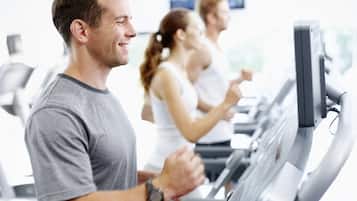 A gym with treadmills and people exercising.