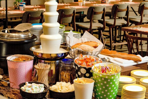 Disposição de buffet com diversos alimentos e utensílios.