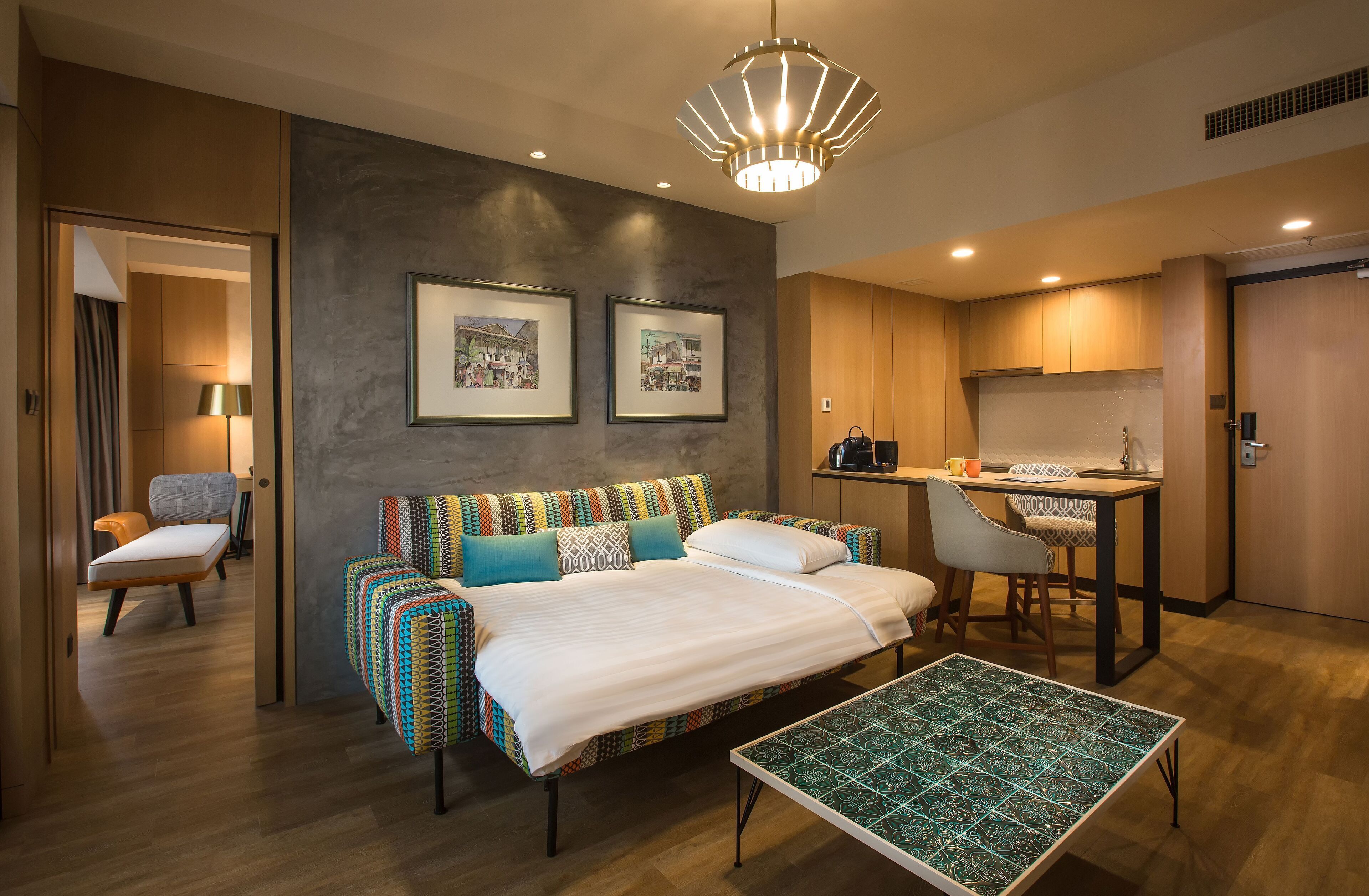 Une chambre d’hôtel moderne équipée d’un lit, d’un canapé, d’une table à manger et d’une kitchenette.