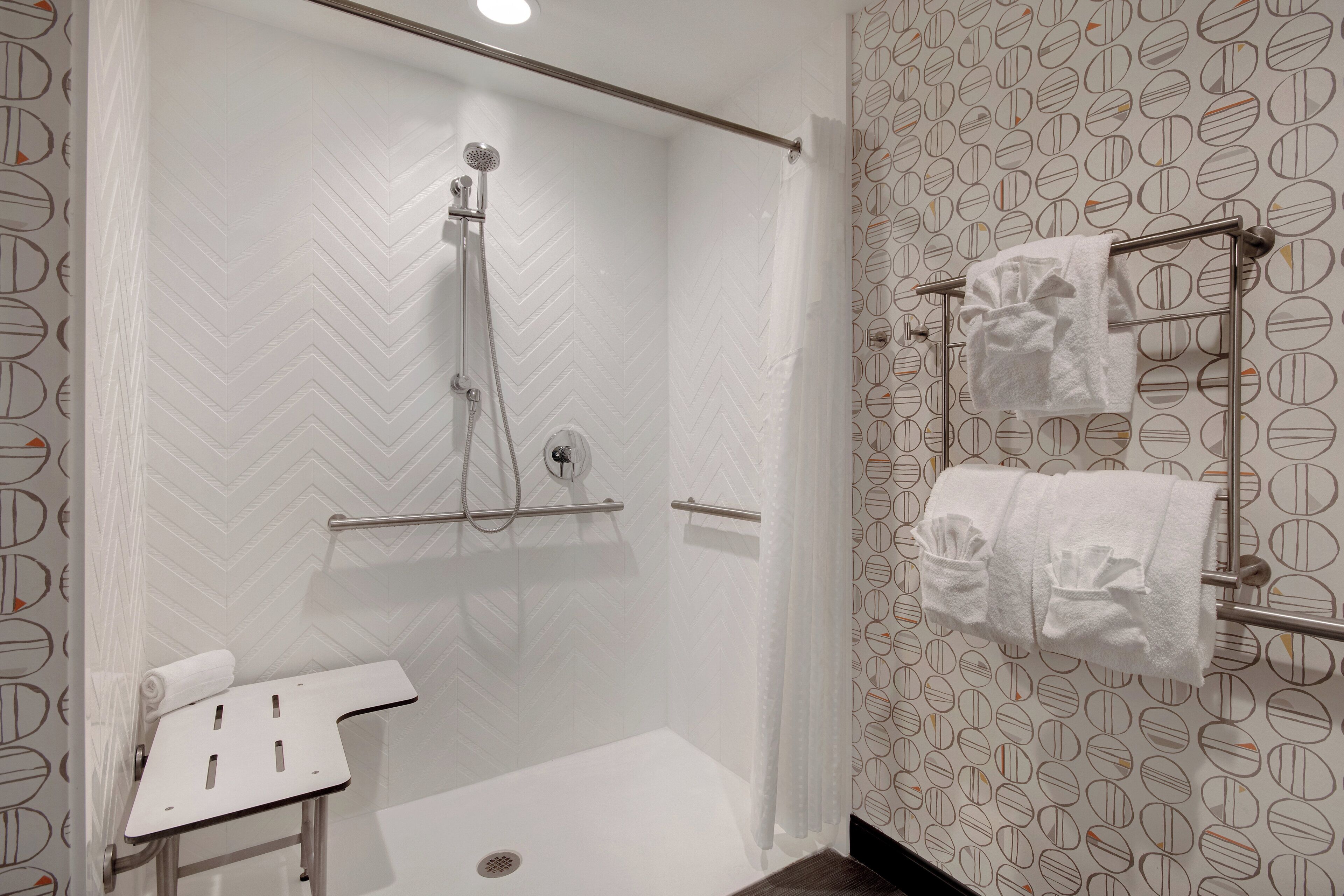 Un baño moderno con ducha, toallero y panel de control de la ducha.