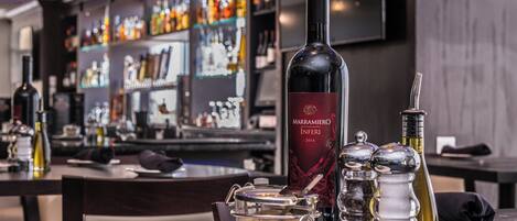 A bar area with a wine bottle, salt and pepper shakers, and a dessert on a plate.
