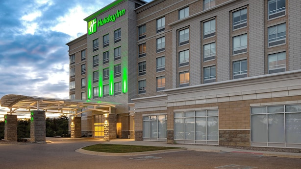 Ein Holiday Inn Hotel mit einer modernen Ziegel-Fassade, großen Fenstern und einem überdachten Eingangsbereich.