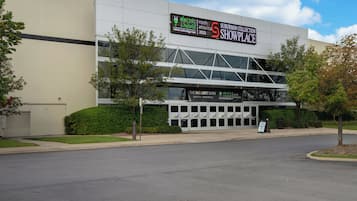 A modern building with a sign for the 'Suburban Collection Showcase' and 'The Battery Show'.