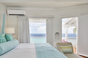 A hotel room with a bed, a chair, a balcony with a view of the ocean, and an air conditioning unit. - Windjammer Landing Resort and Residences (Gros Islet)