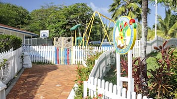 Stroll through the enclosed playground area surrounded by lush greenery and vibrant tropical decor.