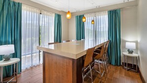 A modern kitchen with a central island, bar stools, and pendant lighting. - Clarion Pointe Cherokee (Cherokee)