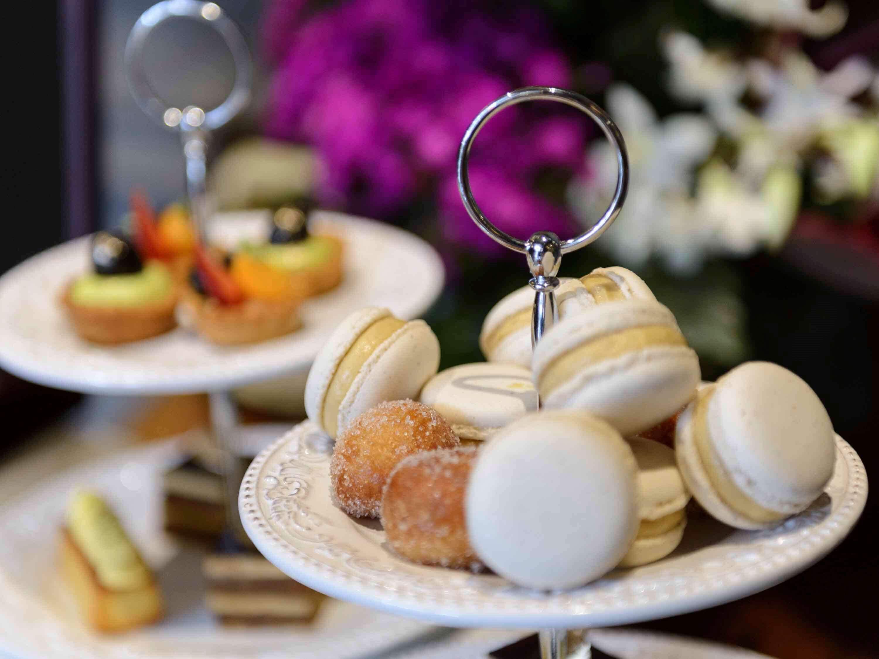 Eine Dessertpräsentation mit Macarons und anderen Süßigkeiten auf weißen Tellern.
