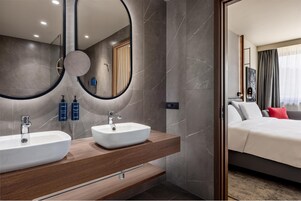 Un baño moderno con dos lavamanos, un espejo grande y un mueble de tocador de madera.