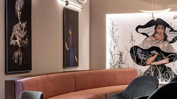 Un espace détente moderne avec un canapé incurvé, des chaises noires et une table ronde.