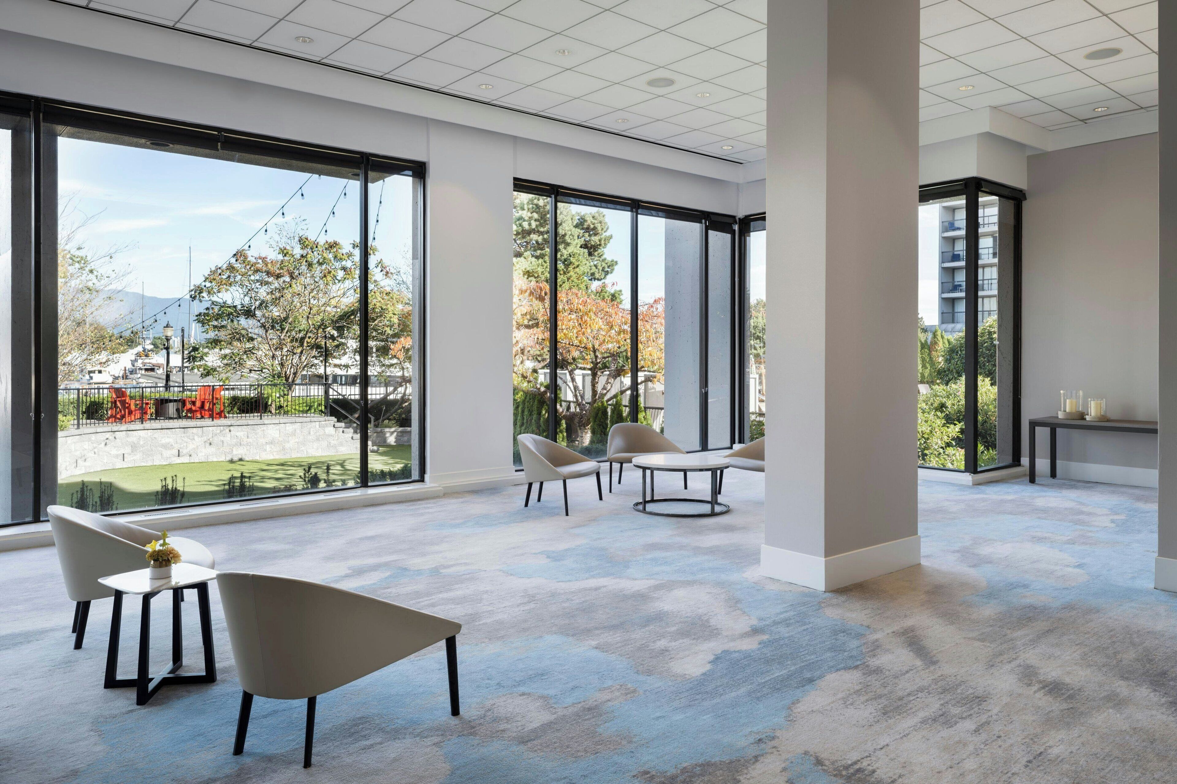Um quarto espaçoso com janelas amplas, decoração moderna e vista para o exterior.