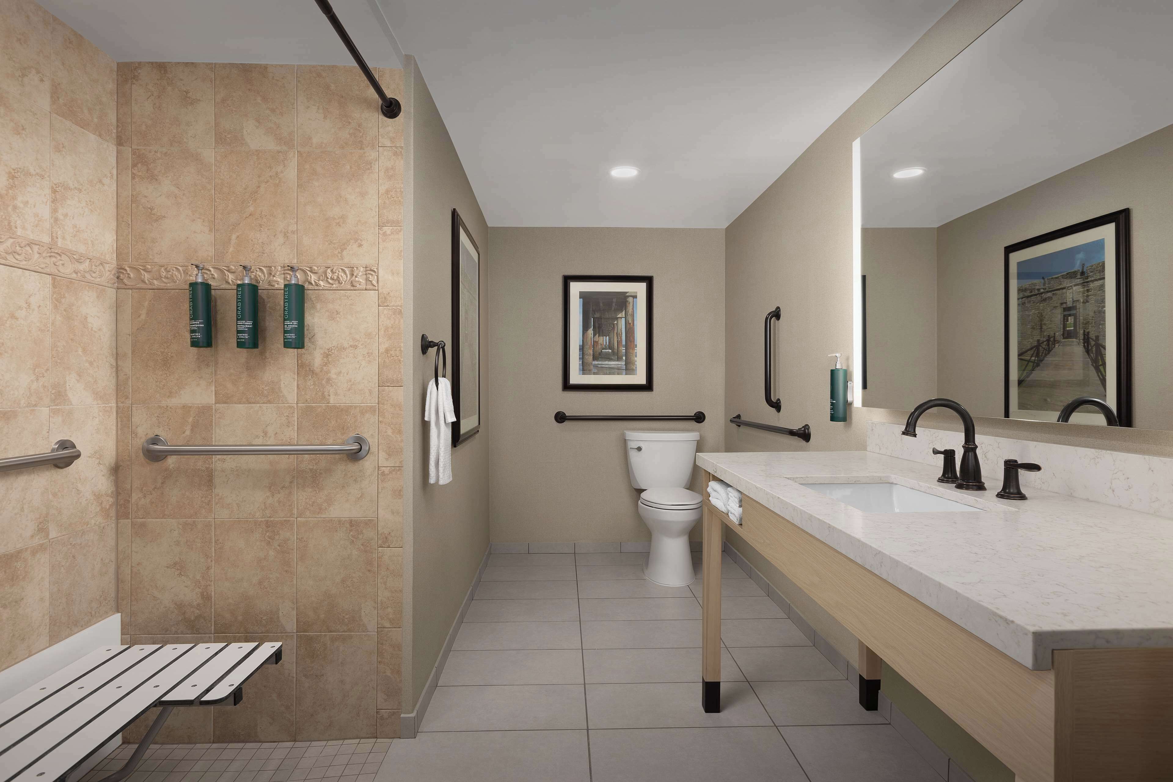 Une salle de bain moderne équipée d’une douche, de toilettes et d’un meuble-lavabo.