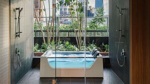 A modern bathroom with a glass-enclosed hot tub, city views, and a minimalist design. - PARKROYAL COLLECTION Kuala Lumpur (Kuala Lumpur)