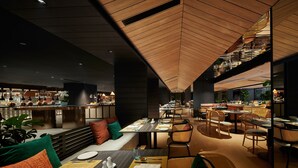 A modern restaurant interior with wooden ceiling panels, round tables, and comfortable seating. - PARKROYAL COLLECTION Kuala Lumpur (Kuala Lumpur)