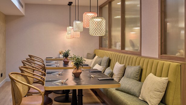 A modern dining area with a long table, chairs, and a green sofa. - Catalonia Mikado (Barcelona)