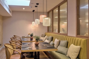 A modern dining area with a long table, chairs, and a green sofa. - Catalonia Mikado (Barcelona)