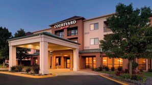 A Courtyard Marriott hotel with a covered entrance, multiple floors, and a landscaped garden.
