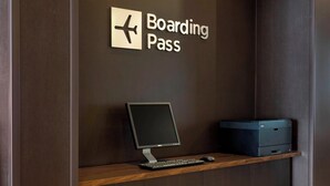 A desk with a computer, a keyboard, and a mouse, and a sign that reads "Boarding Pass".