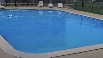 Piscine extérieure en saison, chaises longues