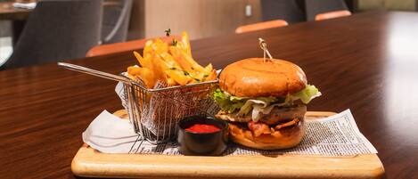 A dining table with a burger, fries, and ketchup.