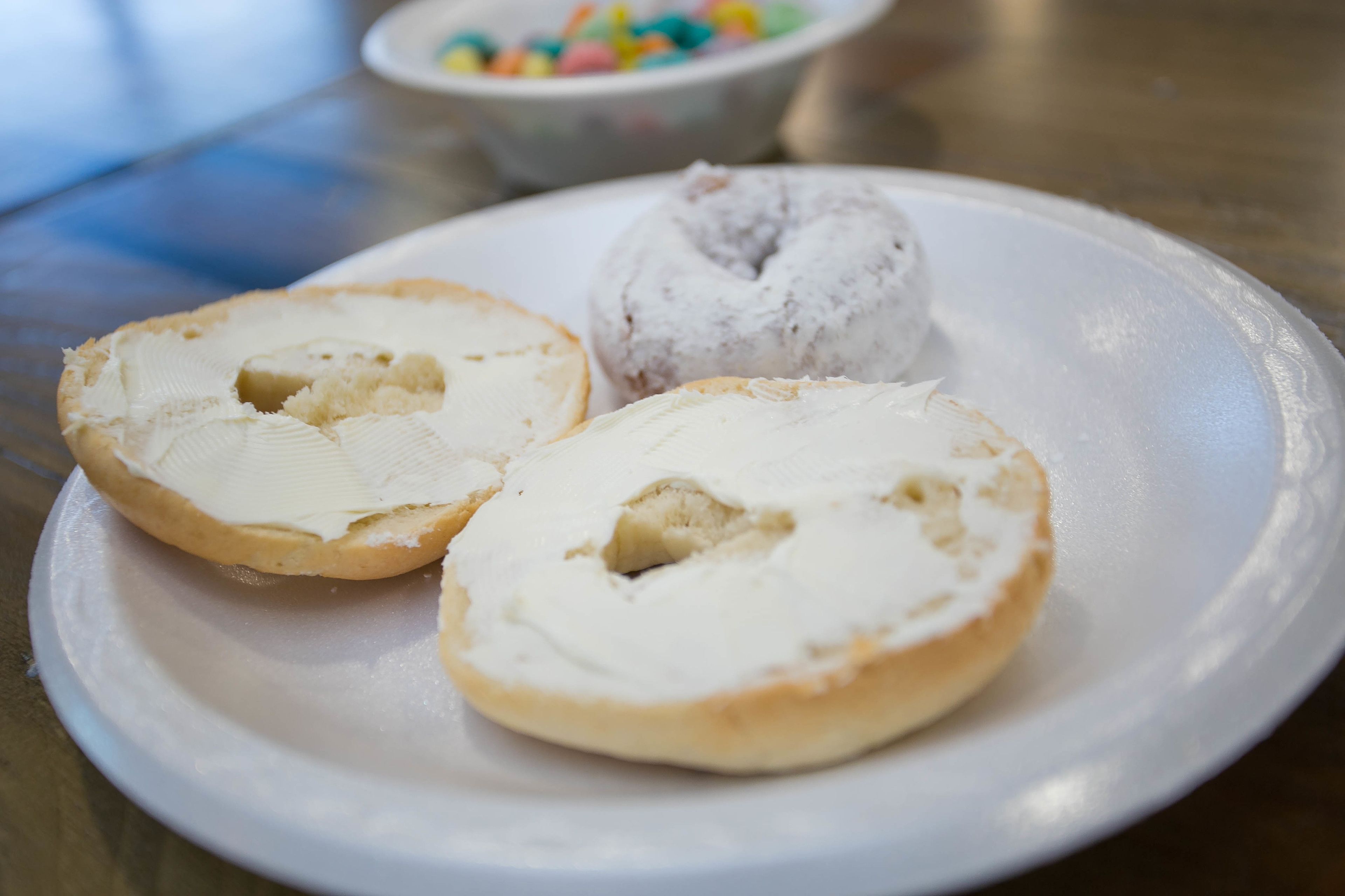 A plate with two halves of a pastry and a whole pastry with frosting.