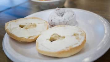 A plate with two halves of a pastry and a whole pastry with frosting.