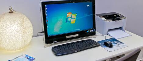 Ein Schreibtisch mit einem Desktop-Computer, einer Tastatur, einer Maus, einer Lampe und einigen Dokumenten.