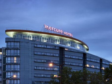 A hotel with a modern design, featuring a prominent sign at the top.. Mercure Paris 19 Philharmonie La Villette