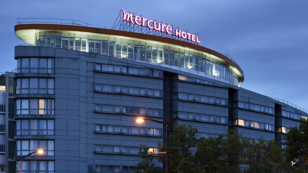 Un hôtel reconnaissable à son grand panneau « Mercure Hotel », avec de nombreux étages et une architecture moderne.