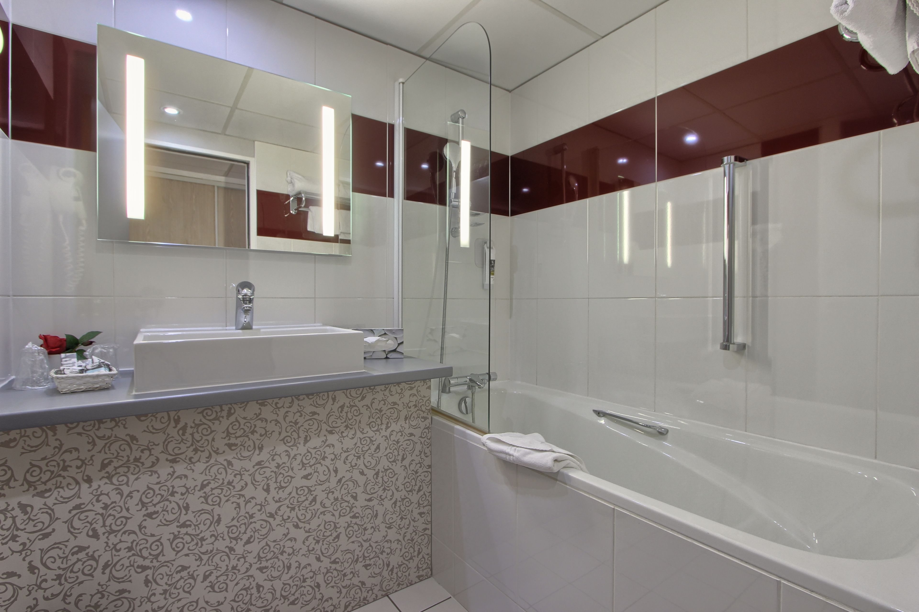 A modern bathroom with a large mirror, two sinks, a shower, and a bathtub.