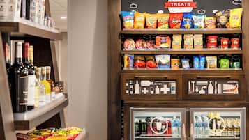 A snack and beverage display with various brands and types of snacks, a selection of bottled beverages, and a refrigerated section with drinks.