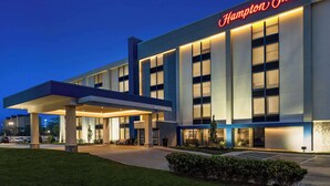 Un hôtel Hampton Inn doté d’une façade moderne, de grandes fenêtres et d’une entrée accueillante.