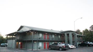 A motel with multiple rooms, a parking lot, and a streetlight.