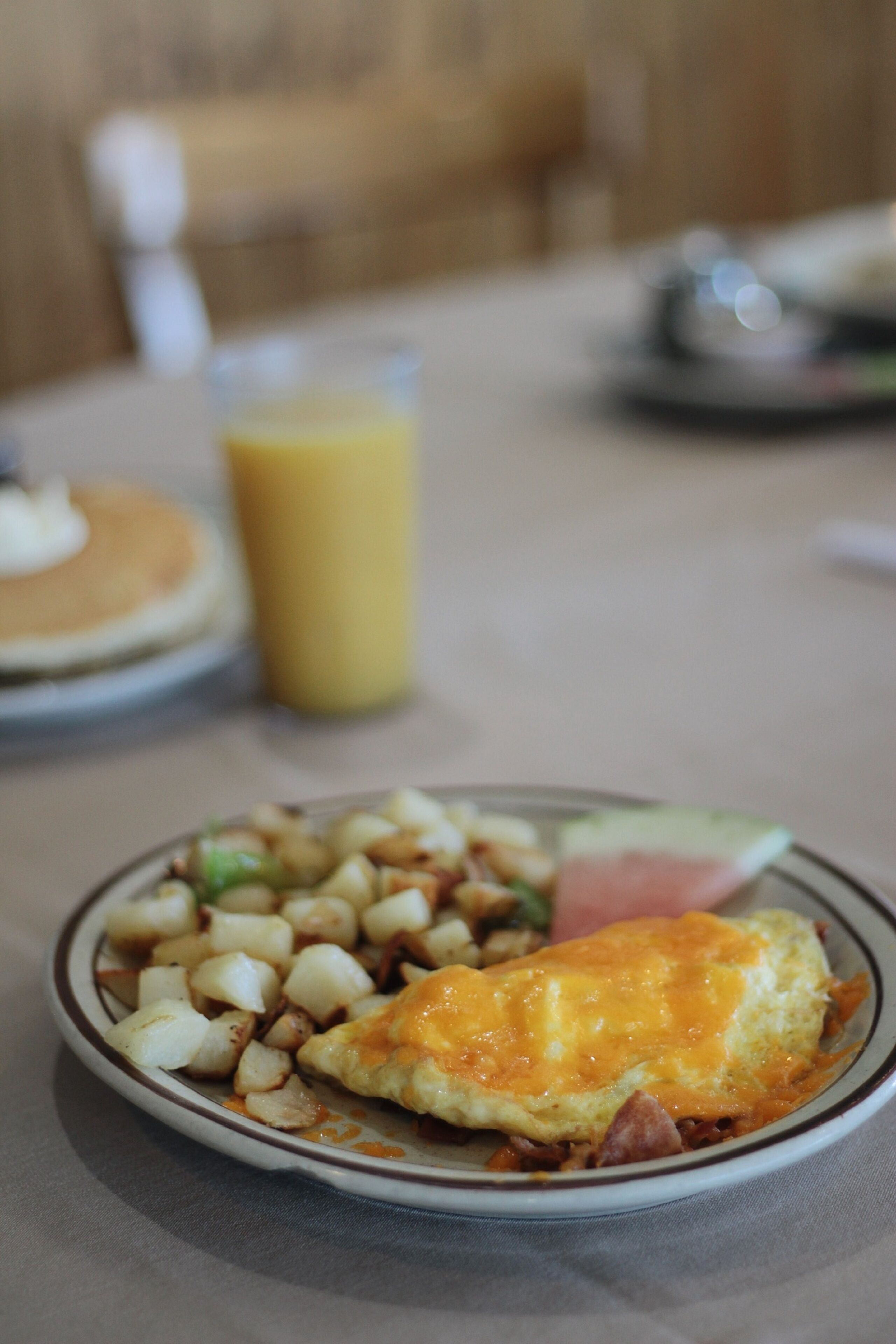 A breakfast plate with eggs, potatoes, and ham.