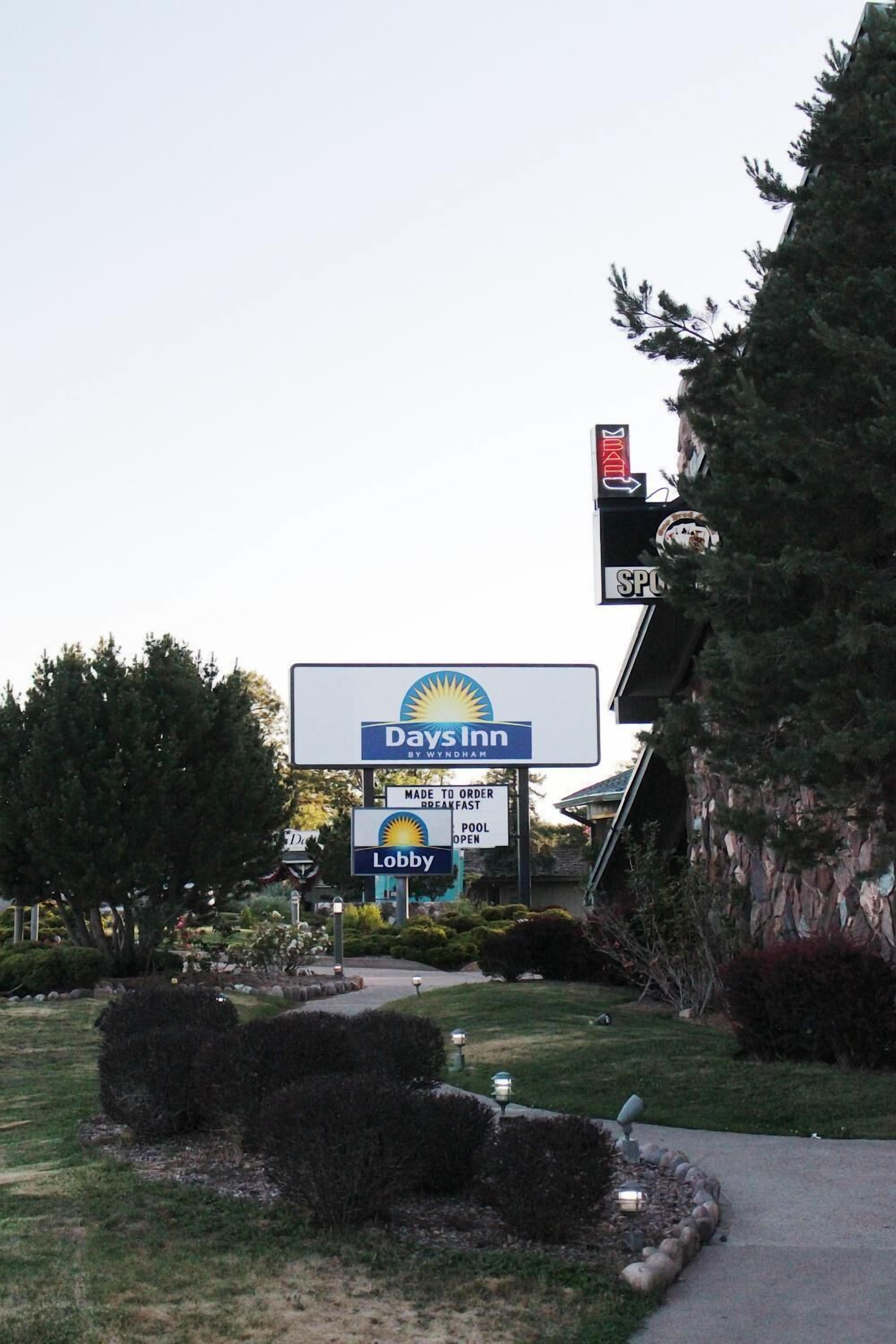 A Days Inn sign with a pool and lobby open notice.