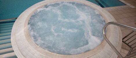 A hot tub with a textured edge and a metal ladder.