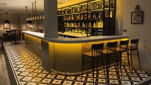 A bar area with a checkered floor, a bar counter, and multiple stools. - The Aberdeen Altens Hotel (Aberdeen)