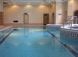 An indoor swimming pool with clear water, tiled walls, and a 'Staff Only' door.