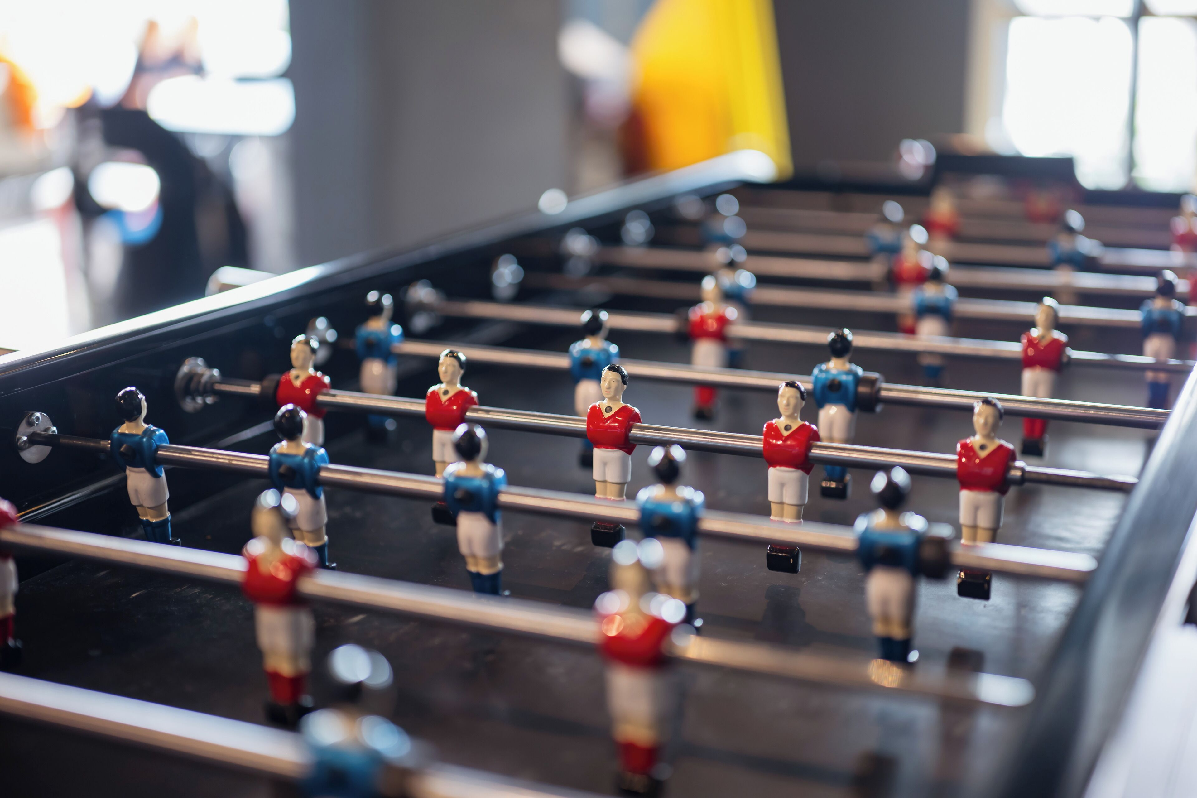 A foosball table with players in red and blue uniforms.