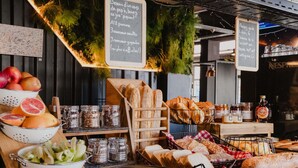 Une vitrine de boulangerie présentant divers pains, fruits et condiments.