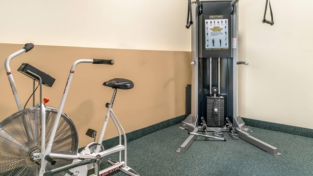 Una bicicleta estática y una máquina de pesas en un gimnasio.