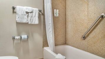 A bathroom with a bathtub, a toilet, and a shower curtain.