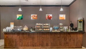 Una barra de desayuno con diferentes alimentos y una máquina de café.