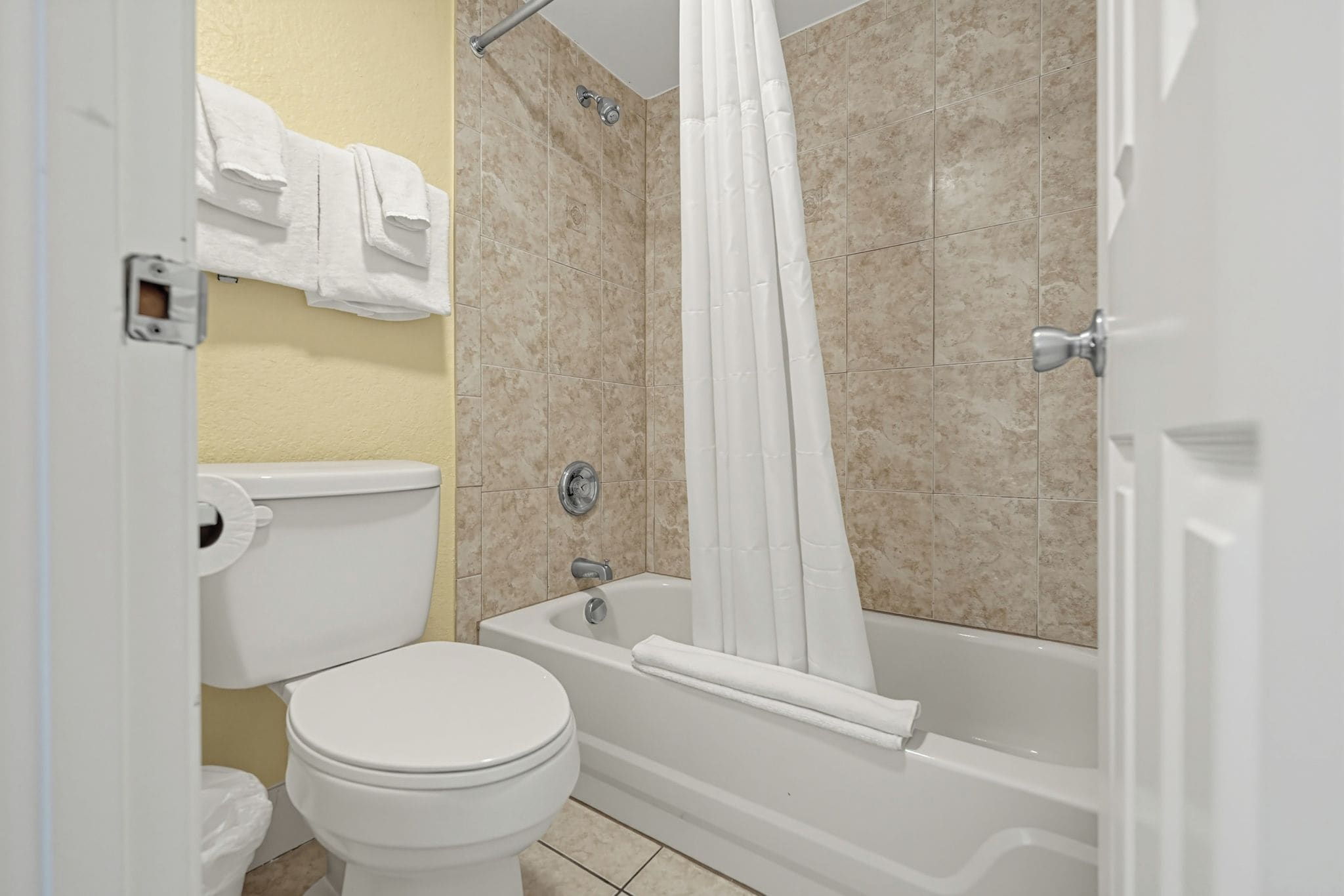 A bathroom with a toilet, bathtub, and shower curtain.