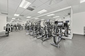 A gym with various exercise machines, mirrors, and a sauna area. - Silver Lake Resort (Kissimmee)