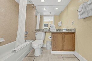 A bathroom with a bathtub, toilet, and vanity.