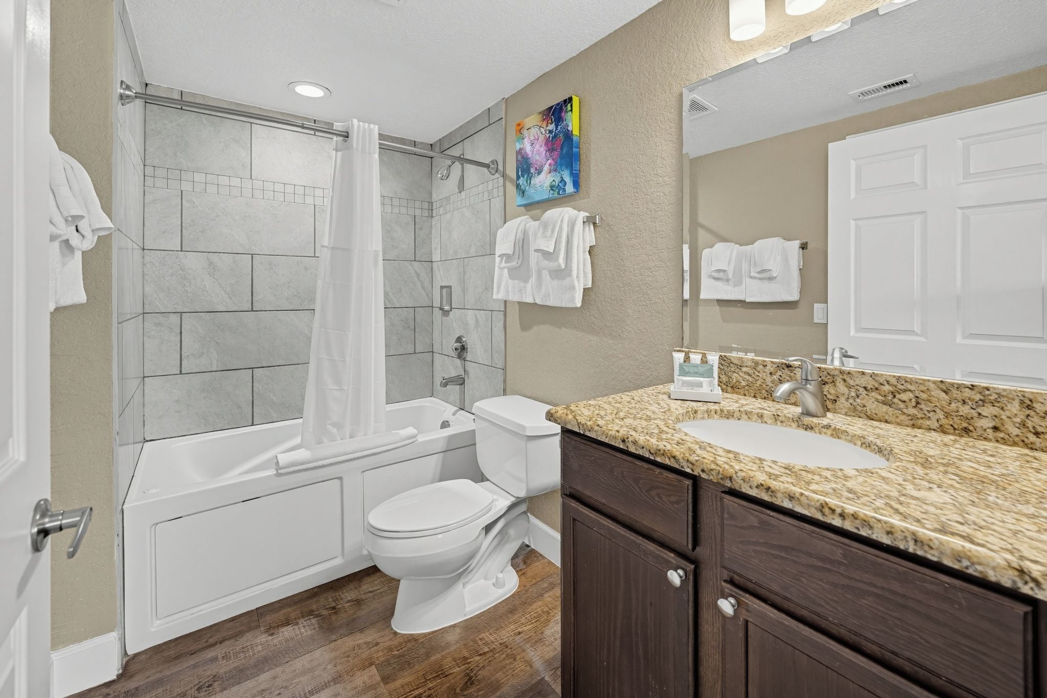 A bathroom with a bathtub, toilet, and sink.