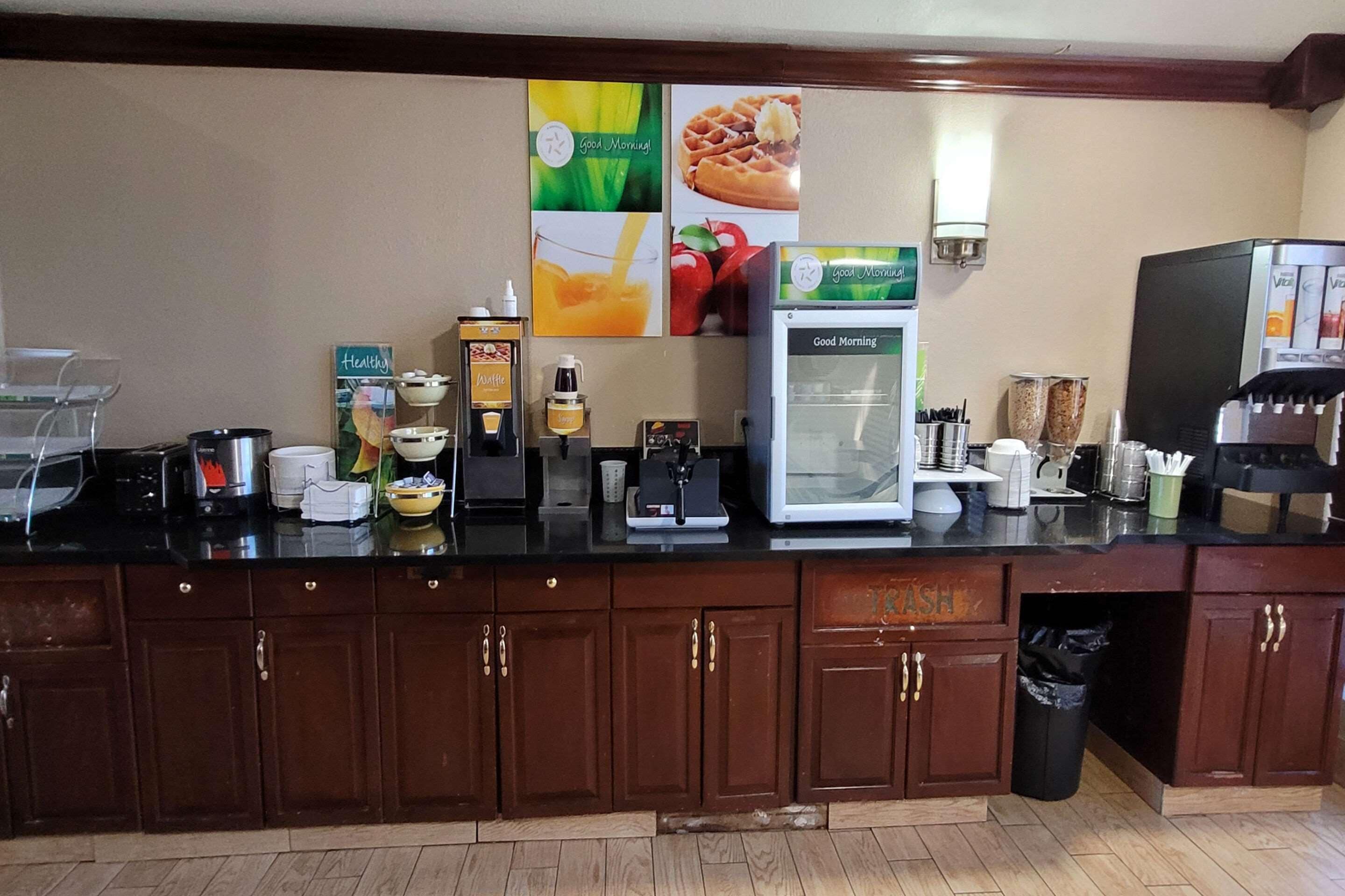 A kitchen area with a coffee machine, a refrigerator, and various kitchen appliances.